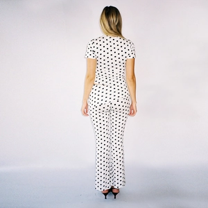 Vue arrière de l'ensemble deux pièces pour femme à pois noirs sur haut et pantalon blancs
