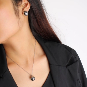 Quilted texture 18K gold sphere pendant necklace and earrings set worn by a model