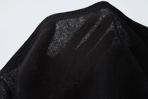 Détail du tissu en maille noire transparente montrant la texture légère et la finesse