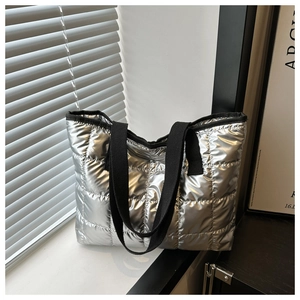 Detailed shot of large silver quilted tote bag with diamond stitching and black straps