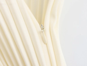 Detailed macro view of the pleated beige fabric and matching invisible zipper closure