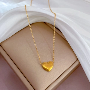 Vue détaillée du pendentif cœur 3D doré poli sur une chaîne fine de haute qualité