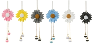 Flat lay of six colorful daisy car hanging ornaments with glass bottles and tassels