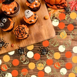Mix of pumpkin and round confetti on dark wood for Thanksgiving and autumn parties