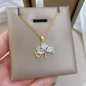 Close-up of golden clover pendant with sparkling clear crystals on jewelry display card