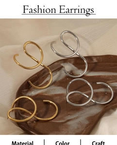 Detail of twisted double hoop earrings in gold and silver finish on silk background