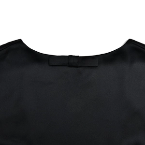 Detalle de un elegante vestido negro sin espalda con un lazo delicado en el cuello trasero