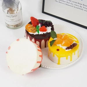 Three assorted 10cm artificial mousse cakes with realistic fruit toppings on a white plate