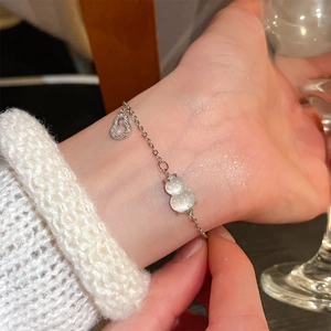 Macro shot of silver zircon gourd charms on a delicate bracelet for women