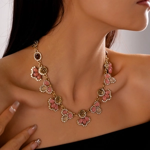 Detail of vintage flower pendant necklace with pink resin stones and crystal accents