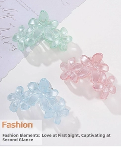 Detailed close-up of translucent floral hair claws in pastel green, pink, and blue colors