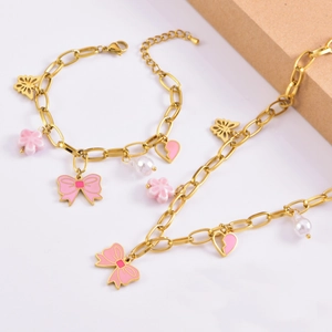Detailed view of gold chain jewelry set with pink enamel bows and pearl charms