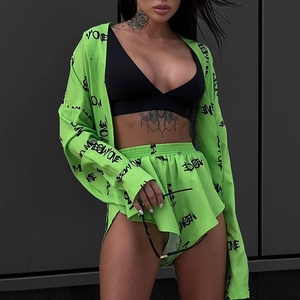 Detail of neon green printed long sleeve top and shorts set with I'M NO ONE graphic text