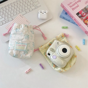 Quilted floral drawstring storage pouches for cameras and electronics in lifestyle setting