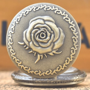 Detailed relief of a blooming rose on a vintage bronze pocket watch cover with fine texture