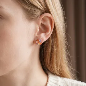 Elegant multi-color flower cluster stud earrings with gold finish on a female model