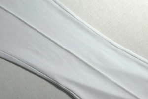 Close-up of double-stitched seams on high-quality white ruched slim-fit fabric
