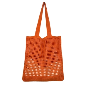 Detail of bright orange knitted tote bag showing its crochet mesh pattern and texture