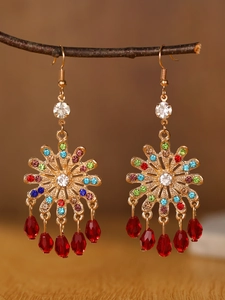 Macro shot of boho alloy flower earrings with colorful rhinestones and red teardrop beads