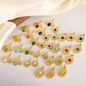 Pendenti vintage dorati a ventaglio con pietre naturali e perle su sfondo di seta