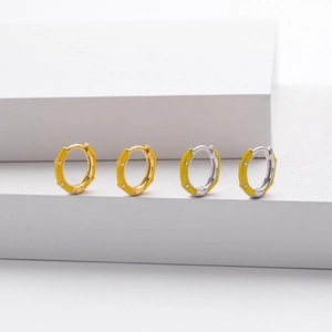 Macro detail of silver and gold hoops with yellow enamel and bamboo texture design