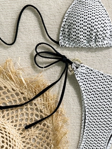 Detail of white crochet bikini with hollow knit texture and side ring decoration