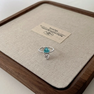 Macro detail of S925 silver ring featuring blue triangle and clear heart cut zircon stones