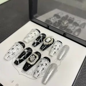 Macro shot of gothic press-on nails with pearl inlay and vintage relief portrait on card