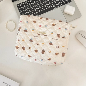 Macro detail of quilted makeup bag with cute cartoon bread dog and embroidery label