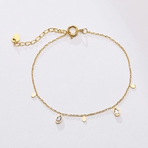 Detail of gold titanium necklace featuring zircon waterdrop and round metal charms