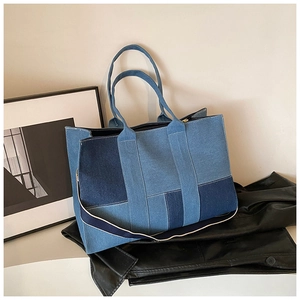 Detail of blue denim patchwork tote bag showing fabric texture and shoulder strap