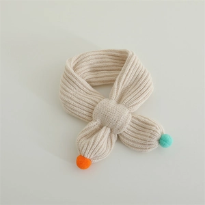 Detail of baby knitted scarf with soft pompom decorations and vertical ribbed texture