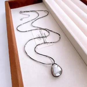 Minimalist double layer necklace with polished silver teardrop pendant and beaded black cord
