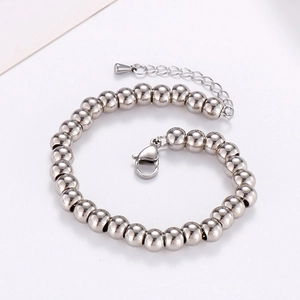 Dettaglio di bracciale con perle in acciaio inossidabile con chiusura a moschettone