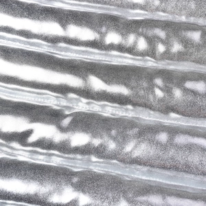 Macro view of metallic silver quilted fabric with water-resistant coating and texture