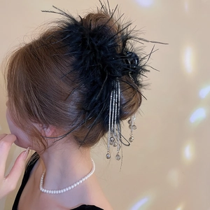 Detail of black feather hair claw with sparkling rhinestone tassels for elegant updos