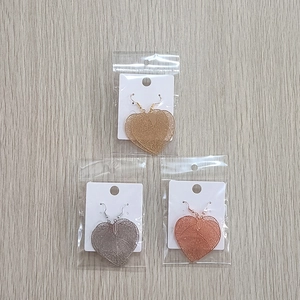Detailed macro view of hollow leaf earrings in gold, silver, and rose gold plating