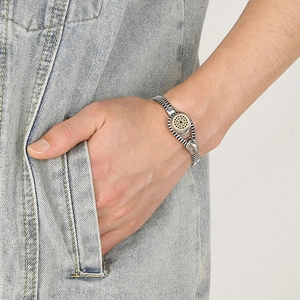Titanium steel zipper bracelet with golden sun motif worn on wrist for business style