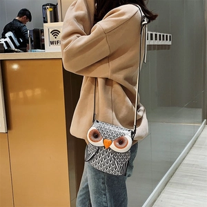 Detailed view of cartoon owl crossbody bag worn by a model in a casual cafe setting