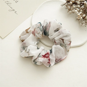 Detail of floral scrunchie with vintage prints on white minimalist display tray