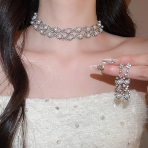 Detail of luxury teardrop pearl and crystal necklace set worn by model in close-up
