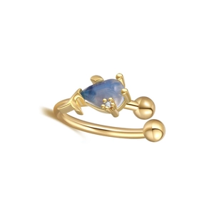 Detailed view of gold ear cuff featuring a pear-shaped blue stone and clear zircon accent