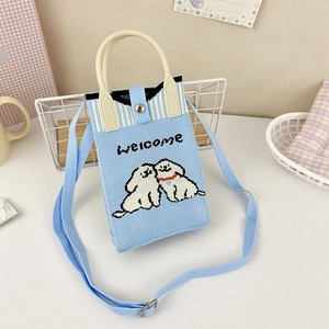 Close-up of light blue knitted handbag with cute dog embroidery and welcome text detail