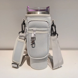 Detail of light gray neoprene sleeve for 40oz tumbler with adjustable strap and pockets