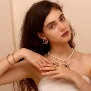 Close-up of elegant gold plated coffee bean chain bracelet and floral jewelry set