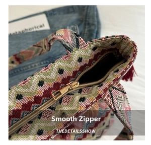 Detailed macro view of the smooth golden zipper and colorful woven texture on the ethnic bag