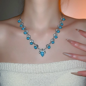 Macro detail of bohemian turquoise necklace with silver base and vintage drop gems