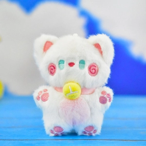 Close-up of cute white cat plush toy with pink embroidery and yellow bell.