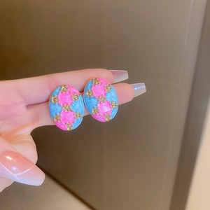 Macro detail of oval vintage enamel floral stud earrings with pink and blue texture