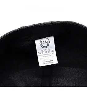 Detail of care label on cotton newsboy hat showing 100 percent cotton and wash symbols